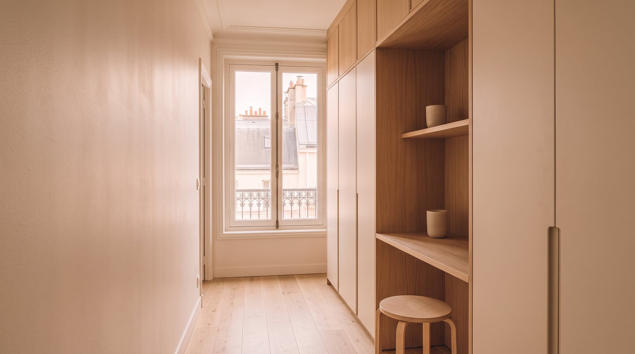 Niche de couloir aménagée avec un petit bureau et une bibliothèque basse encastrés dans l'épaisseur du mur