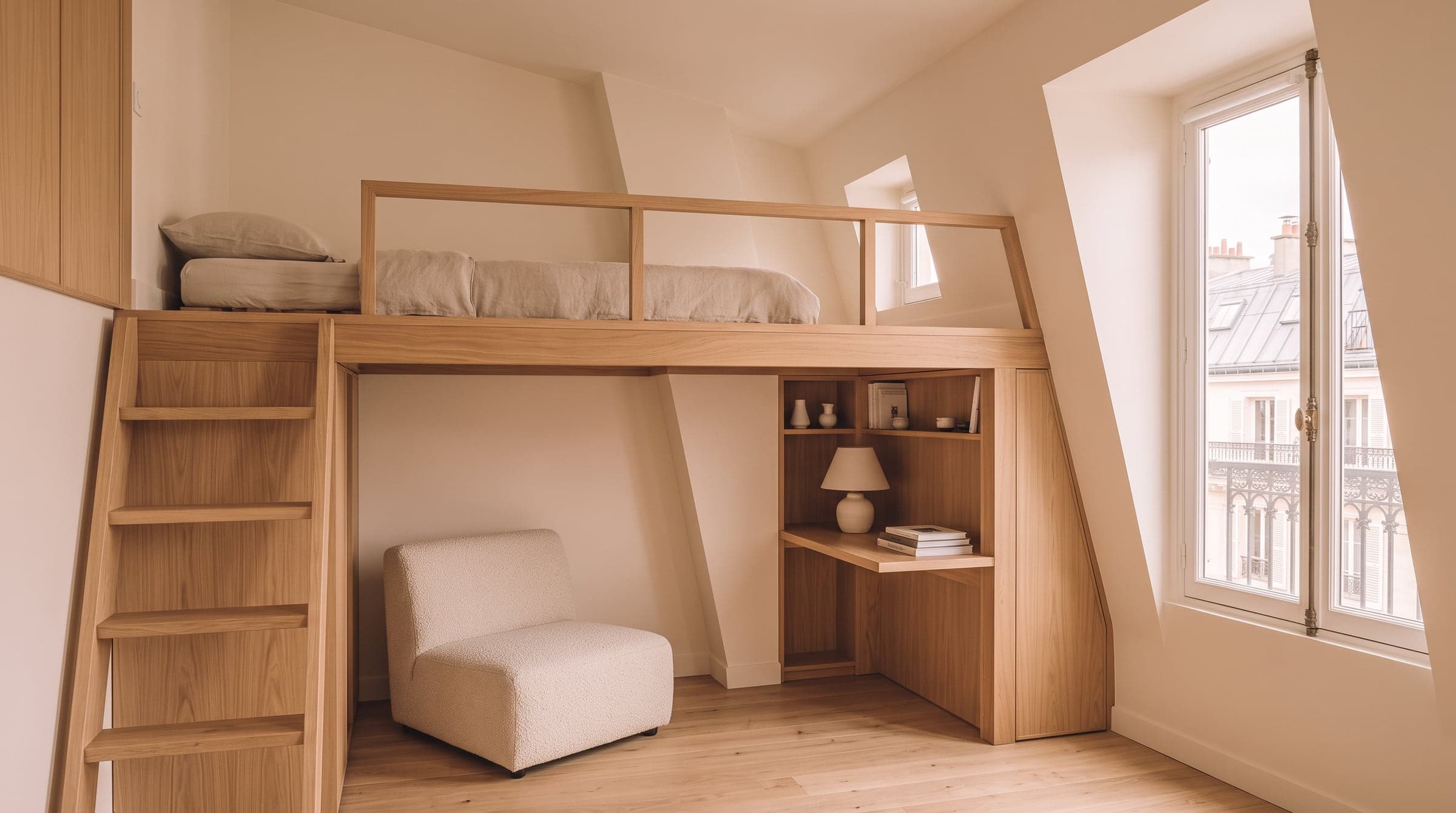 Mezzanine en bois clair au-dessus d'un coin salon dans un studio parisien sous toit haut