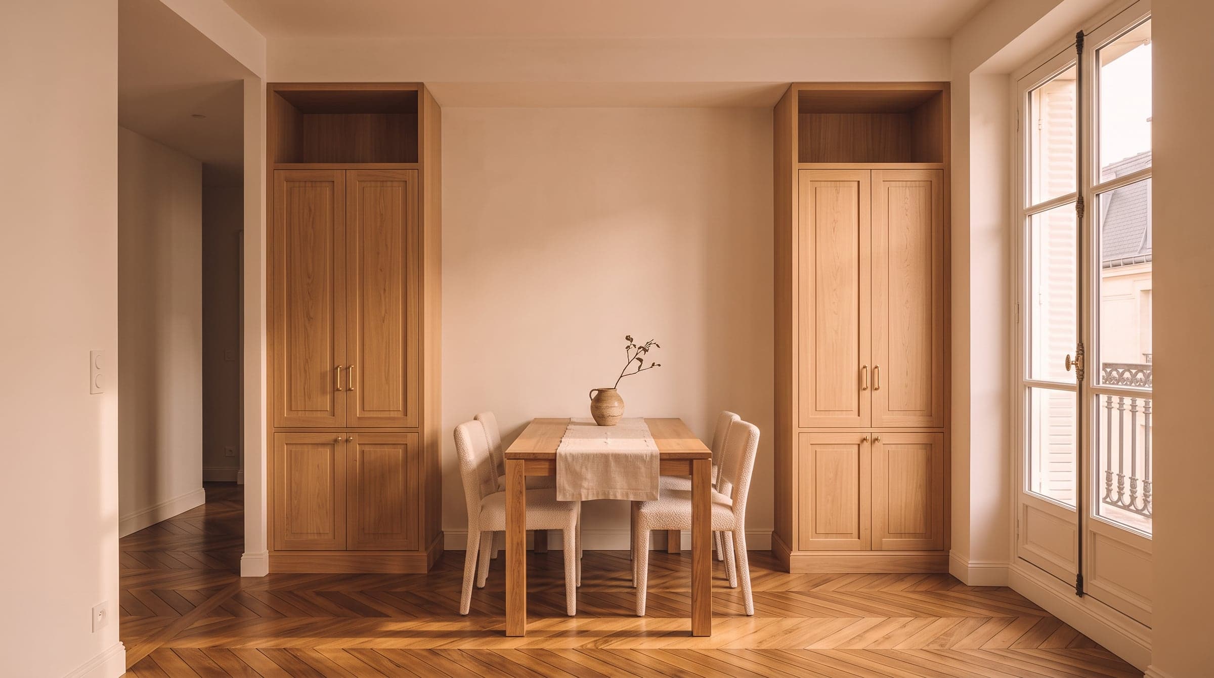 Coin repas avec une table dessinée à la largeur exacte d'une niche, rangements en chêne intégrés de part et d'autre