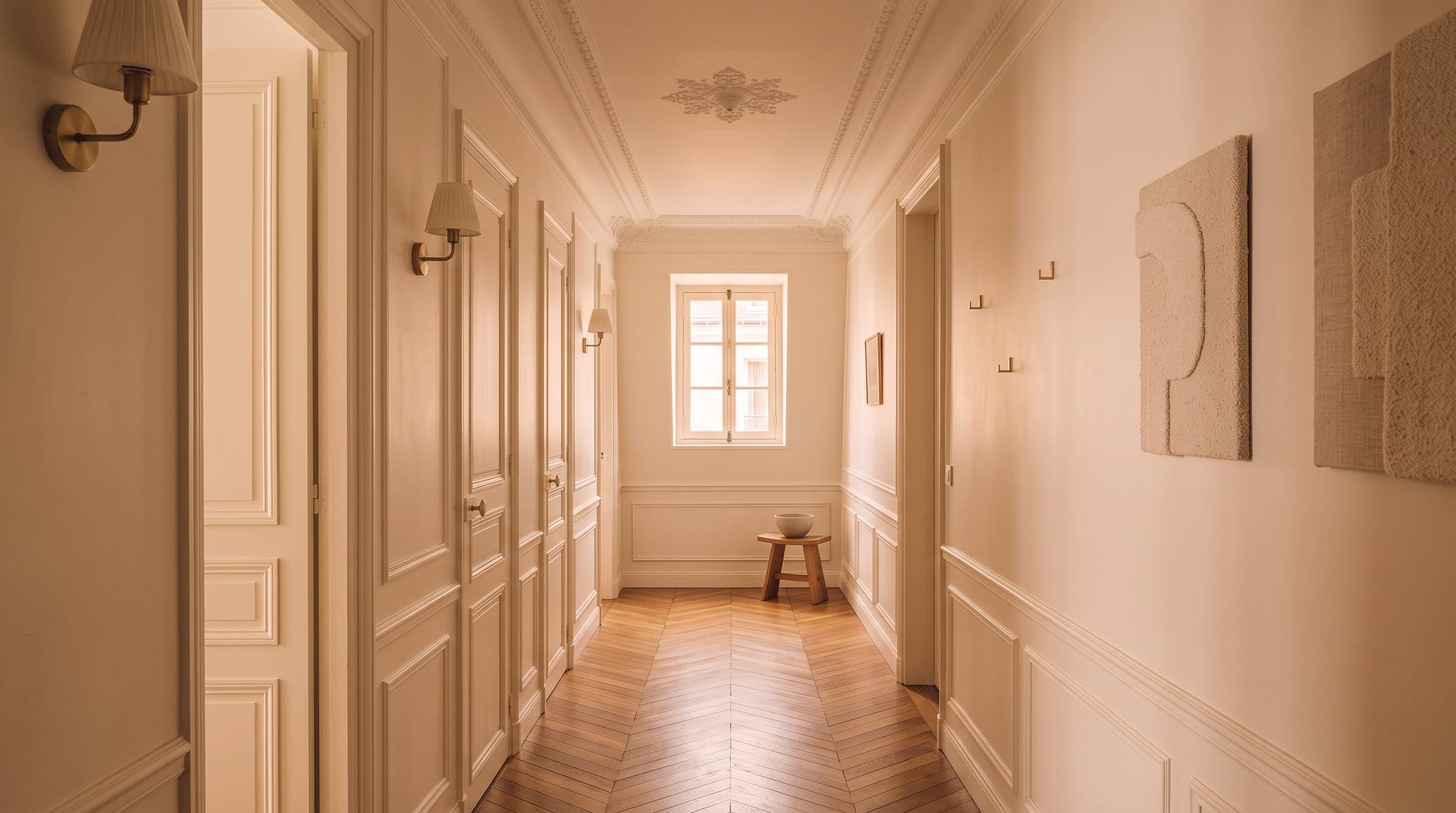 Narrow original corridor in a Haussmann apartment, doors opening along its length toward former service rooms